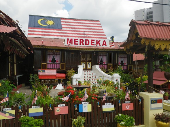 Casa de madera con la bandera malaya pintada en el tejado